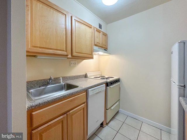 kitchen with light tile patterned floors, dark countertops, a sink, white appliances, and under cabinet range hood