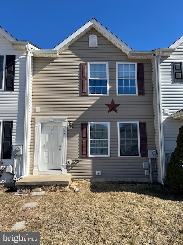 townhome / multi-family property featuring a front lawn