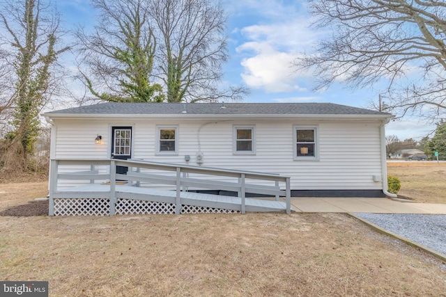 back of property with a deck and a yard