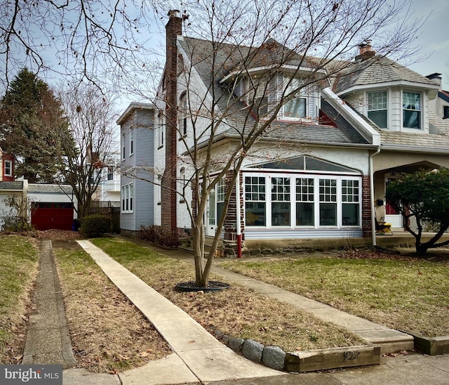 exterior space with a chimney and a front yard