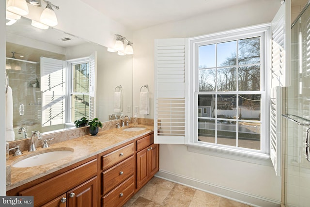 full bathroom featuring a stall shower, double vanity, and a sink