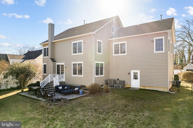 back of house featuring fence, a chimney, a yard, and central AC unit