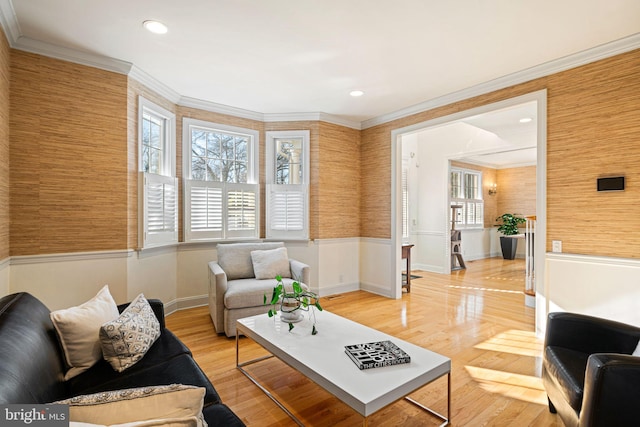 living area with recessed lighting, light wood-type flooring, a wainscoted wall, and ornamental molding