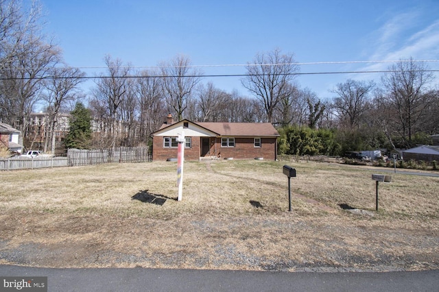 view of front of property with a front lawn, fence, brick siding, and a chimney