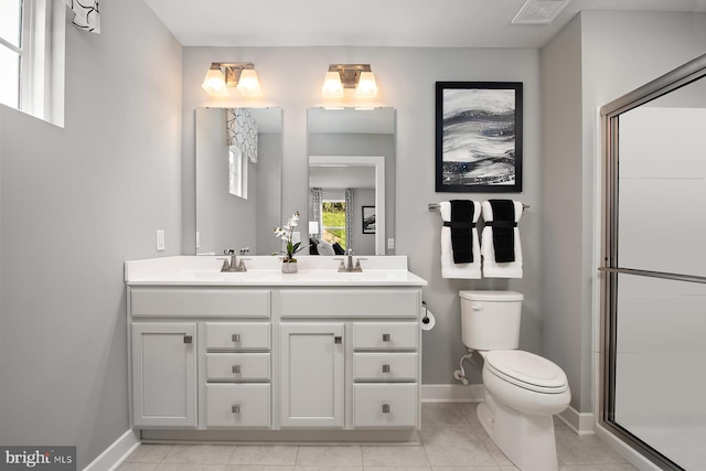 full bath featuring double vanity, a sink, visible vents, and baseboards