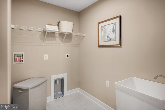 laundry area with light tile patterned floors, hookup for a washing machine, hookup for an electric dryer, a sink, and laundry area