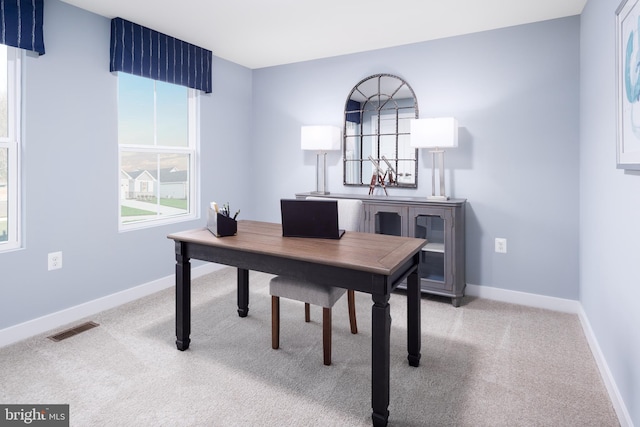 office space with light colored carpet, visible vents, and baseboards