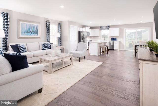 living room with light wood-style floors, recessed lighting, and a healthy amount of sunlight