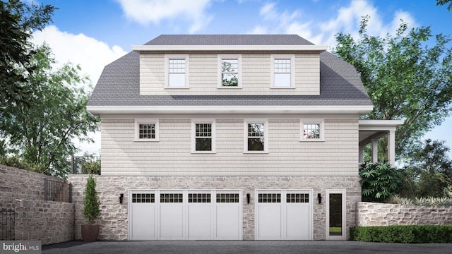 view of side of property with a garage, stone siding, and aphalt driveway