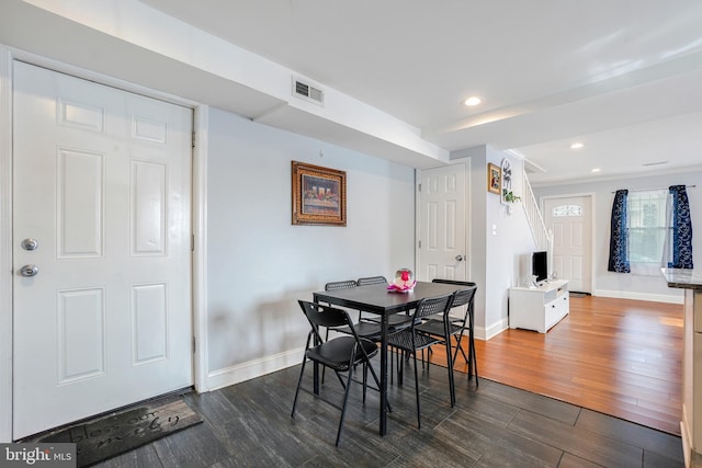 dining area with dark wood-style flooring, visible vents, and baseboards