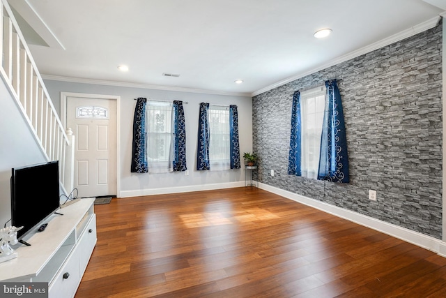 entrance foyer featuring baseboards, visible vents, dark wood finished floors, stairs, and crown molding