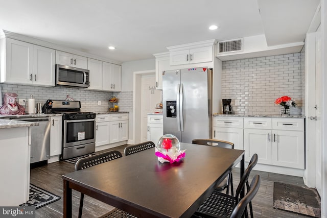 kitchen featuring dark wood-style floors, visible vents, appliances with stainless steel finishes, and white cabinets