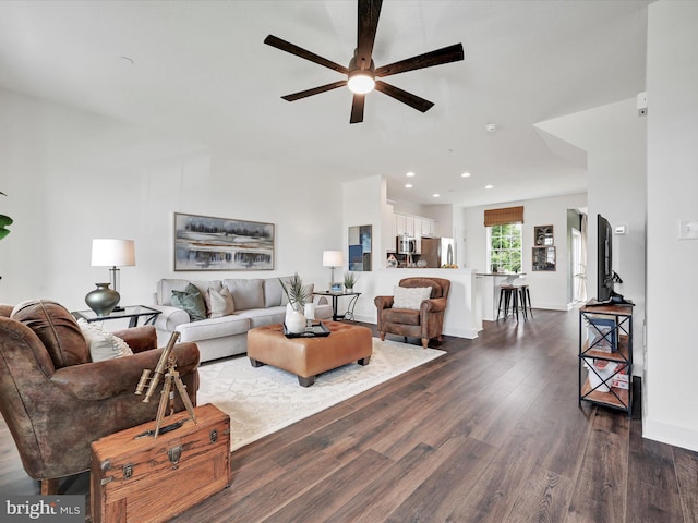 living room featuring dark wood-type flooring and ceiling fan