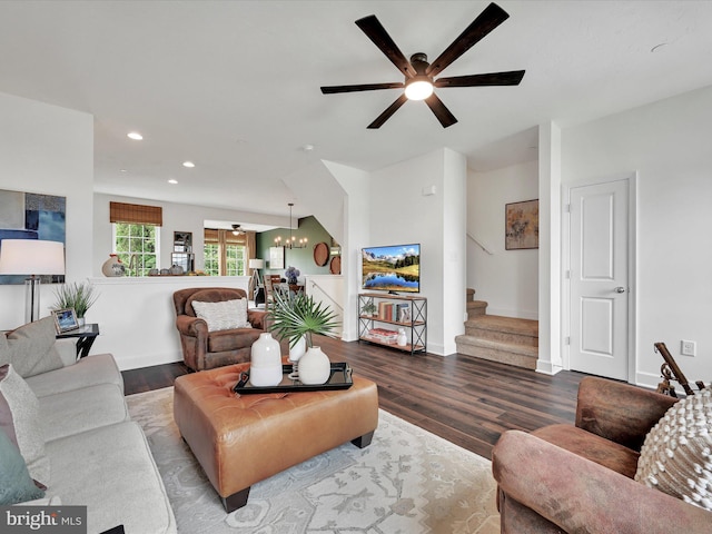 living room with ceiling fan with notable chandelier and wood-type flooring