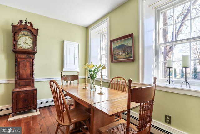 dining space with baseboard heating and dark wood-style flooring