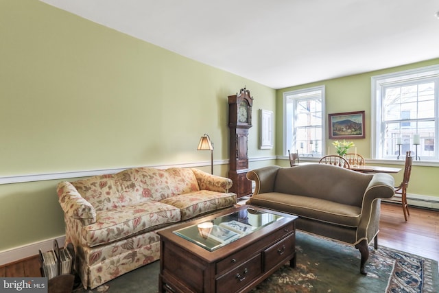 living area with baseboards, baseboard heating, and dark wood-style flooring