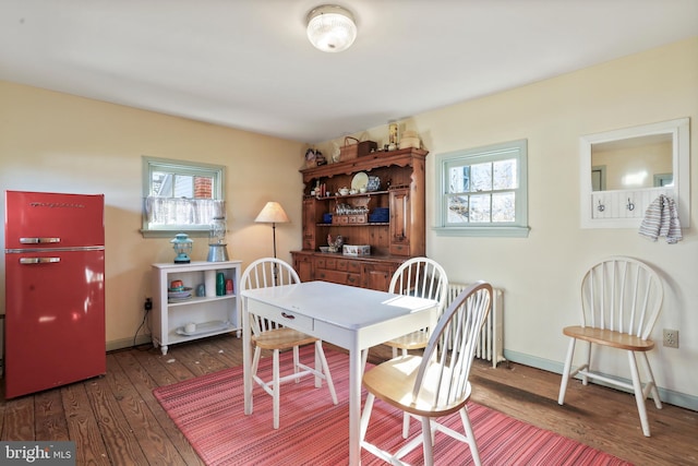 dining area with hardwood / wood-style flooring, radiator heating unit, and baseboards