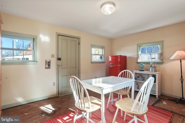 dining room with wood finished floors, baseboards, and a wealth of natural light