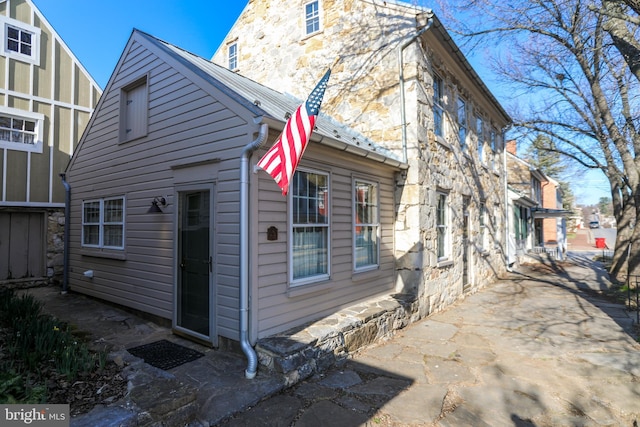 rear view of house featuring stone siding