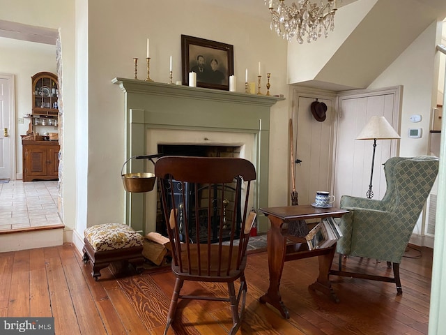 sitting room featuring wood-type flooring and a notable chandelier