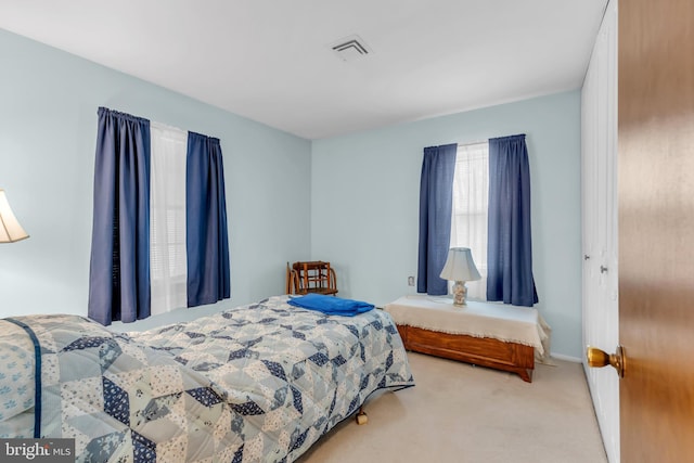 bedroom featuring carpet floors, visible vents, and baseboards