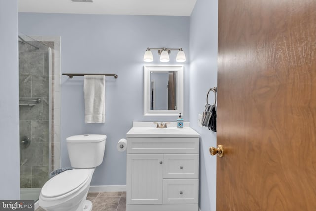 bathroom featuring toilet, a shower stall, baseboards, and vanity