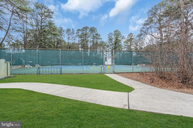 view of sport court featuring a yard, fence, and a gate