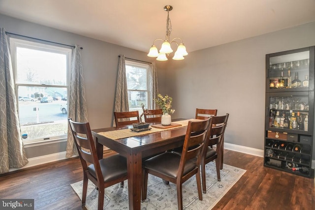 dining space with a notable chandelier and dark hardwood / wood-style floors