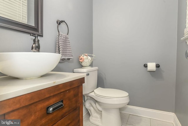 bathroom with toilet, tile patterned flooring, and vanity