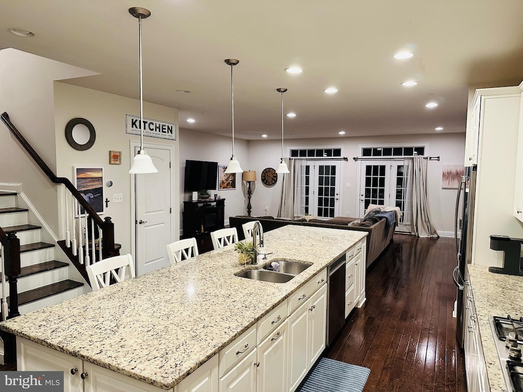 kitchen featuring a large island, stainless steel appliances, recessed lighting, dark wood-type flooring, and a sink