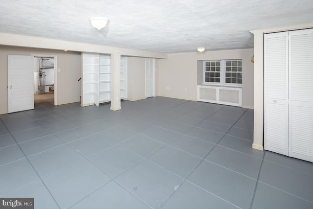 finished below grade area featuring a textured ceiling and tile patterned floors