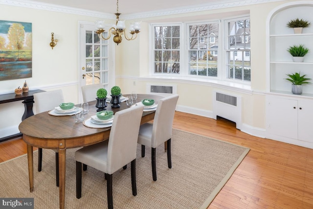 dining area featuring ornamental molding, plenty of natural light, light wood-style flooring, and radiator heating unit