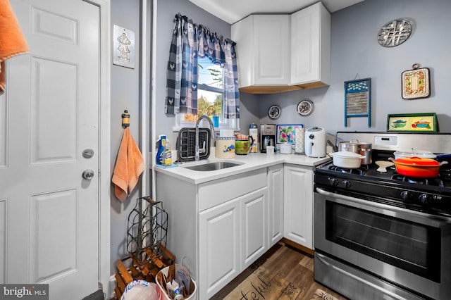 kitchen featuring sink, white cabinetry, dark wood-type flooring, and stainless steel range with gas stovetop