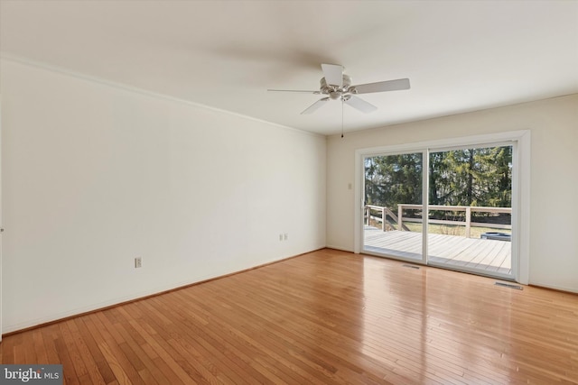 unfurnished room with ceiling fan, hardwood / wood-style floors, visible vents, and baseboards