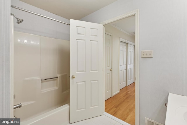 full bathroom featuring ornamental molding, shower / tub combination, and visible vents