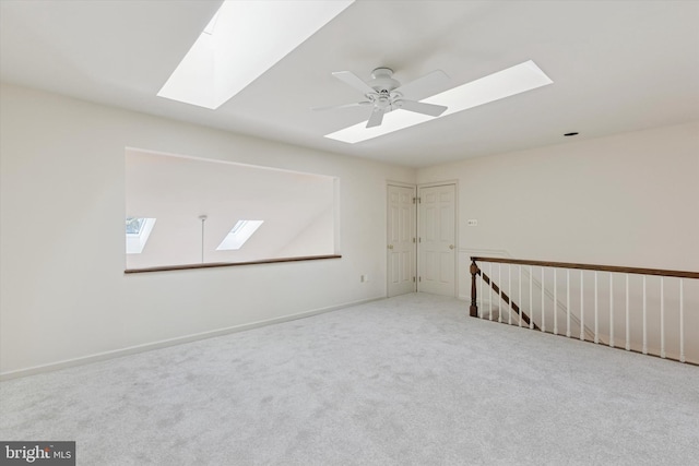 unfurnished room featuring carpet floors, a ceiling fan, and baseboards