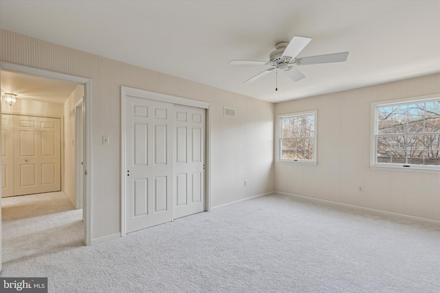 unfurnished bedroom featuring a closet, visible vents, baseboards, and carpet flooring