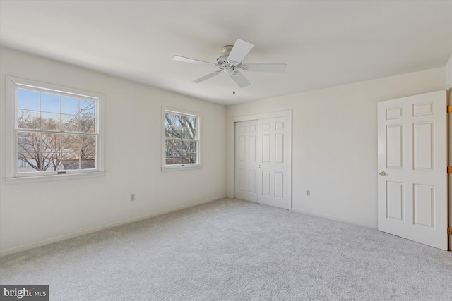 unfurnished bedroom with carpet, a closet, ceiling fan, and baseboards