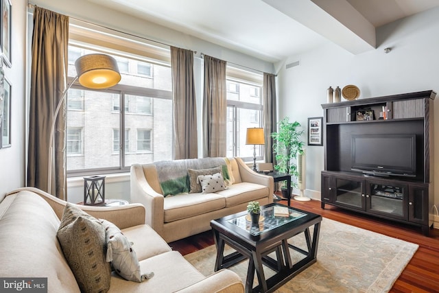 living room featuring visible vents, baseboards, and wood finished floors