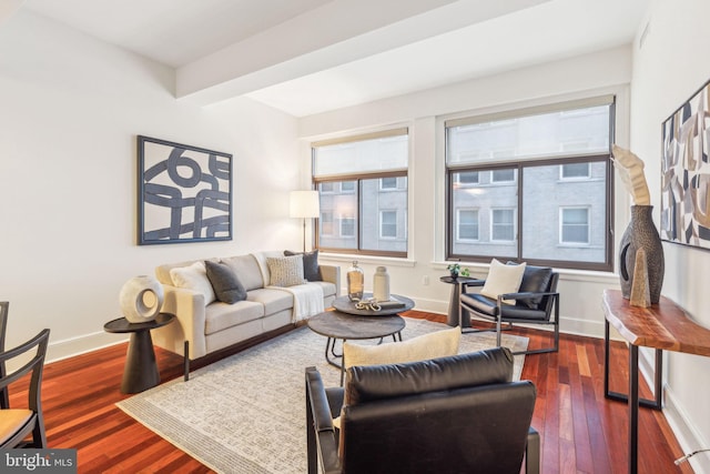 living room featuring dark wood-style floors, beam ceiling, and baseboards