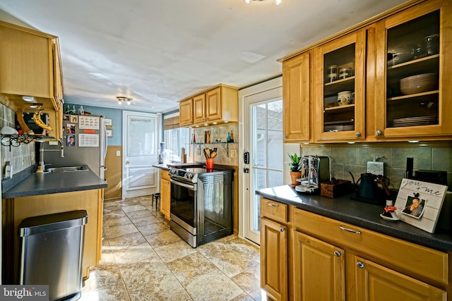 kitchen with glass insert cabinets, dark countertops, stainless steel appliances, and tasteful backsplash