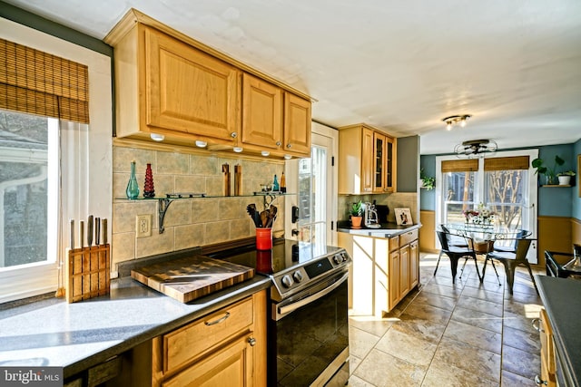 kitchen featuring glass insert cabinets, electric stove, and decorative backsplash