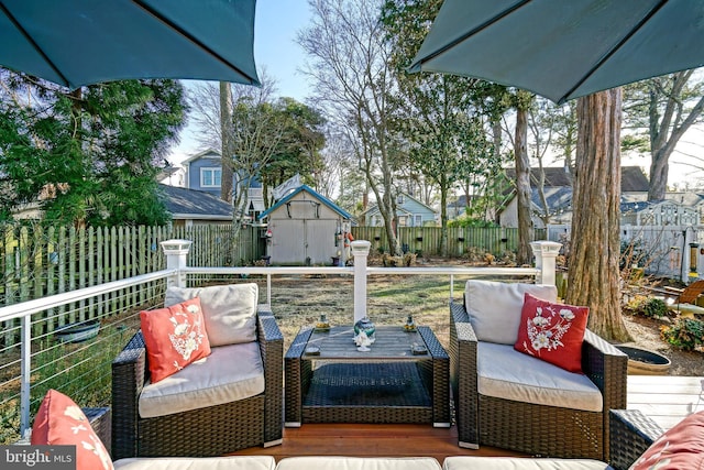 wooden deck featuring an outbuilding, a storage unit, a fenced backyard, and a residential view