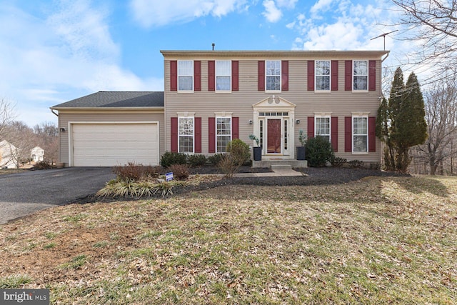 colonial house with an attached garage and driveway