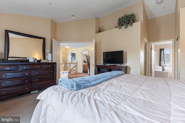 bedroom with carpet, ensuite bath, and a towering ceiling