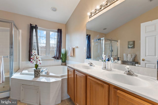 bathroom featuring a stall shower, a garden tub, and a sink