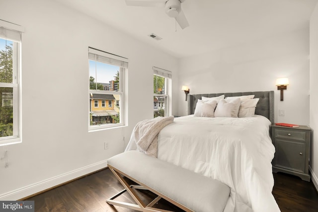 bedroom featuring ceiling fan, dark wood-style flooring, visible vents, and baseboards