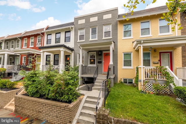 townhome / multi-family property featuring a front yard and brick siding