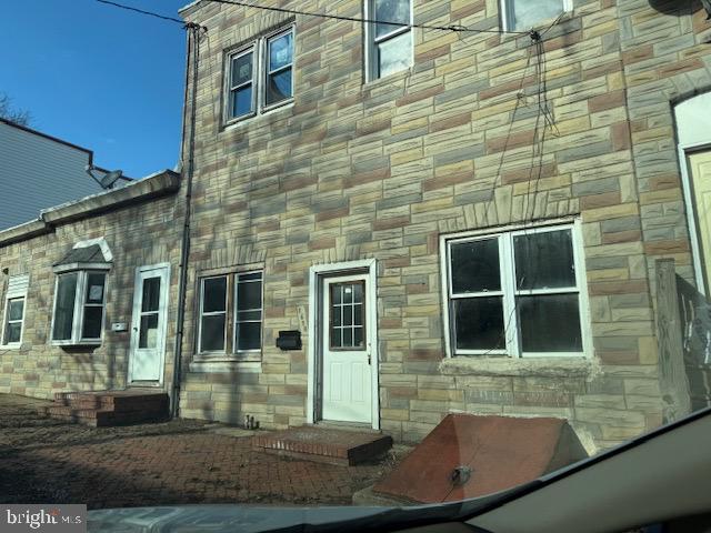 doorway to property featuring stone siding