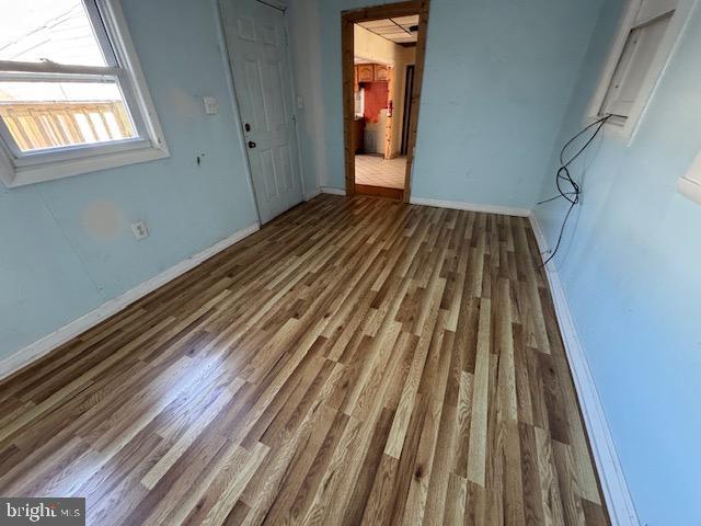 unfurnished bedroom with wood finished floors and baseboards